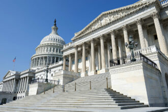 A forced perspective photo of the back of the U.S. Capitol, taken from down low so the building looms.