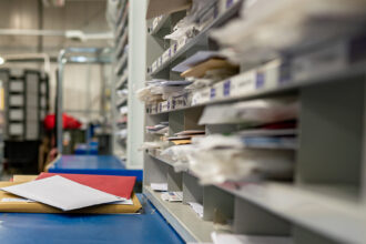 Letters on a sorting frame, table and shelves in a mail delivery sorting center.