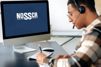 A young man on a headset taking notes on a NOSSCR webinar.