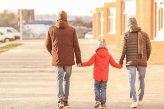 Male couple with adopted boy outdoors