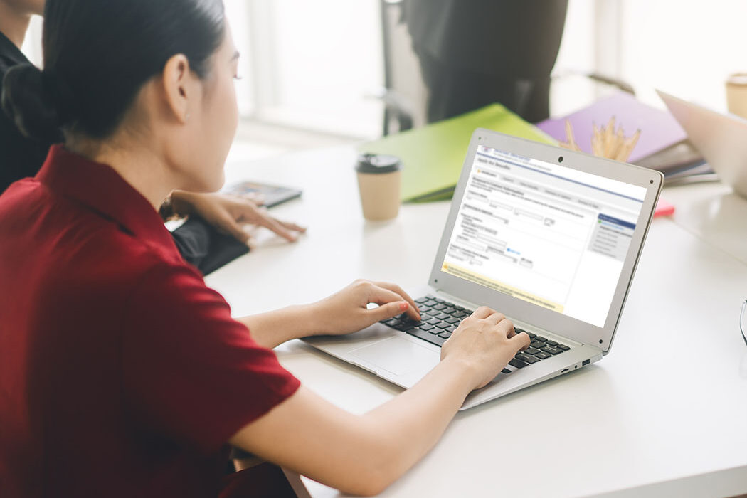 A woman working through the iSSI portal on a laptop.