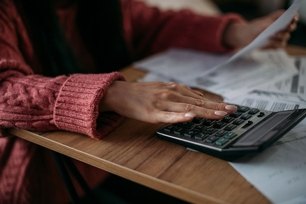 A close up of a woman's hand on a calculator.