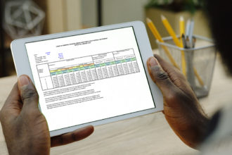 An over the shoulder shot of a black man holding a tablet displaying one of the deeming charts.