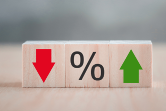 Three wooden blocks in a row. Left: Red arrow pointing down. Center: Black percentage sign. Right: Green arrow pointing up.