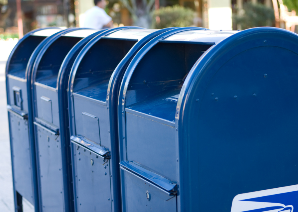 A row of blue post office drop boxes.